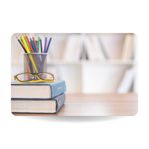 Textbook stack with eyeglasses and stationary on desk in Library. Education concept.