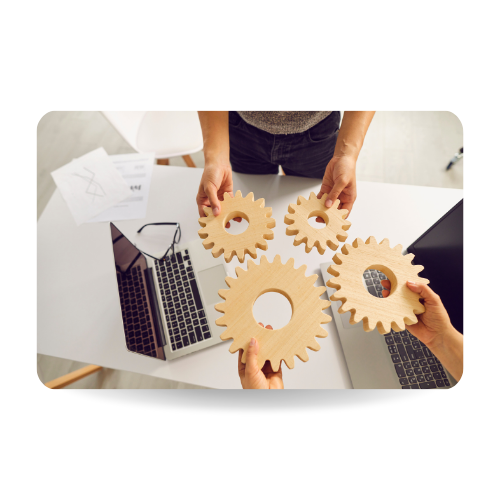 This picture shows teamwork. Hands of business people with gears and laptops in the table, top view